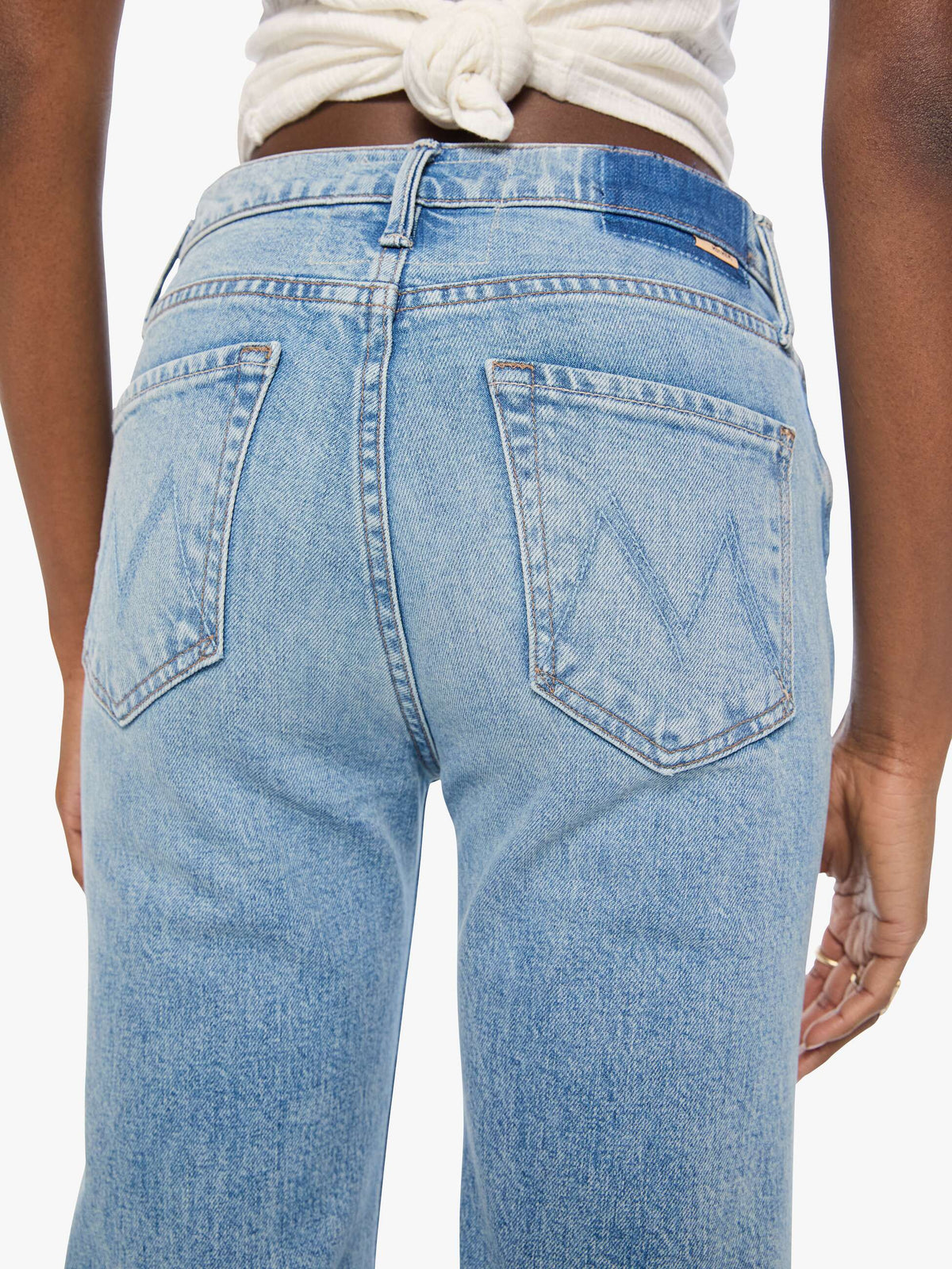 Light blue jeans worn by a person on a white background