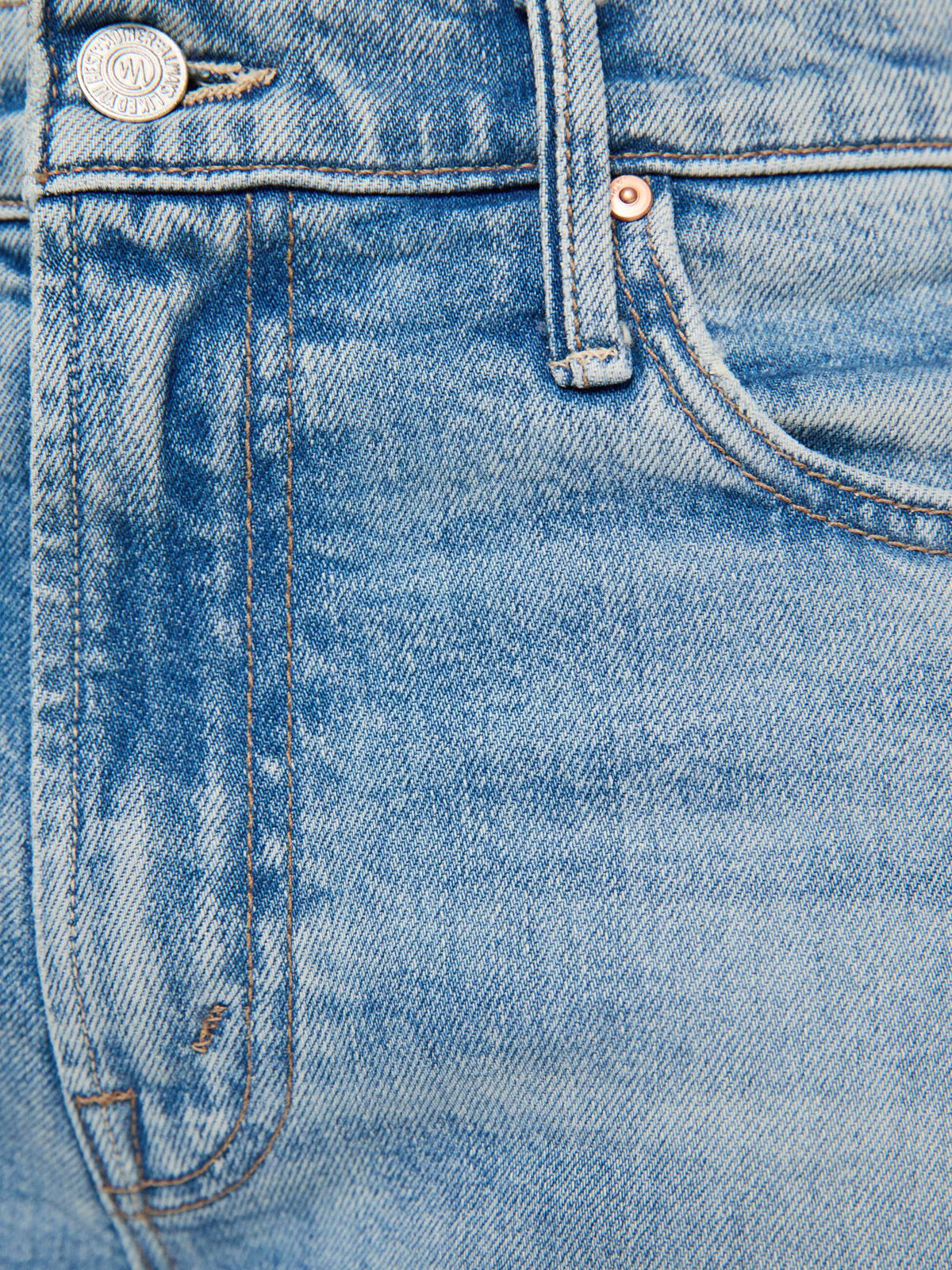 Close-up of blue denim fabric with stitching details