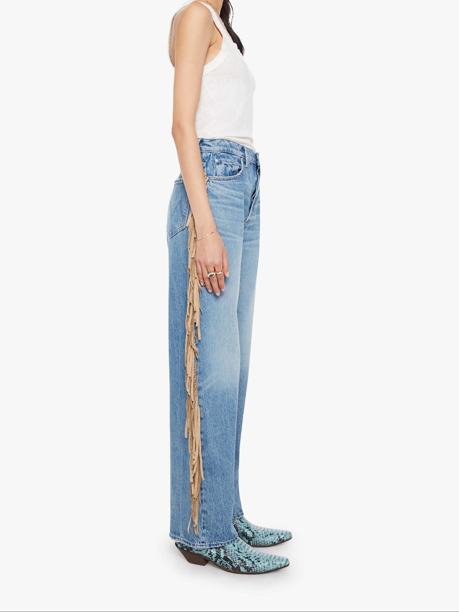 Woman wearing light blue jeans with a decorative side panel on a white background