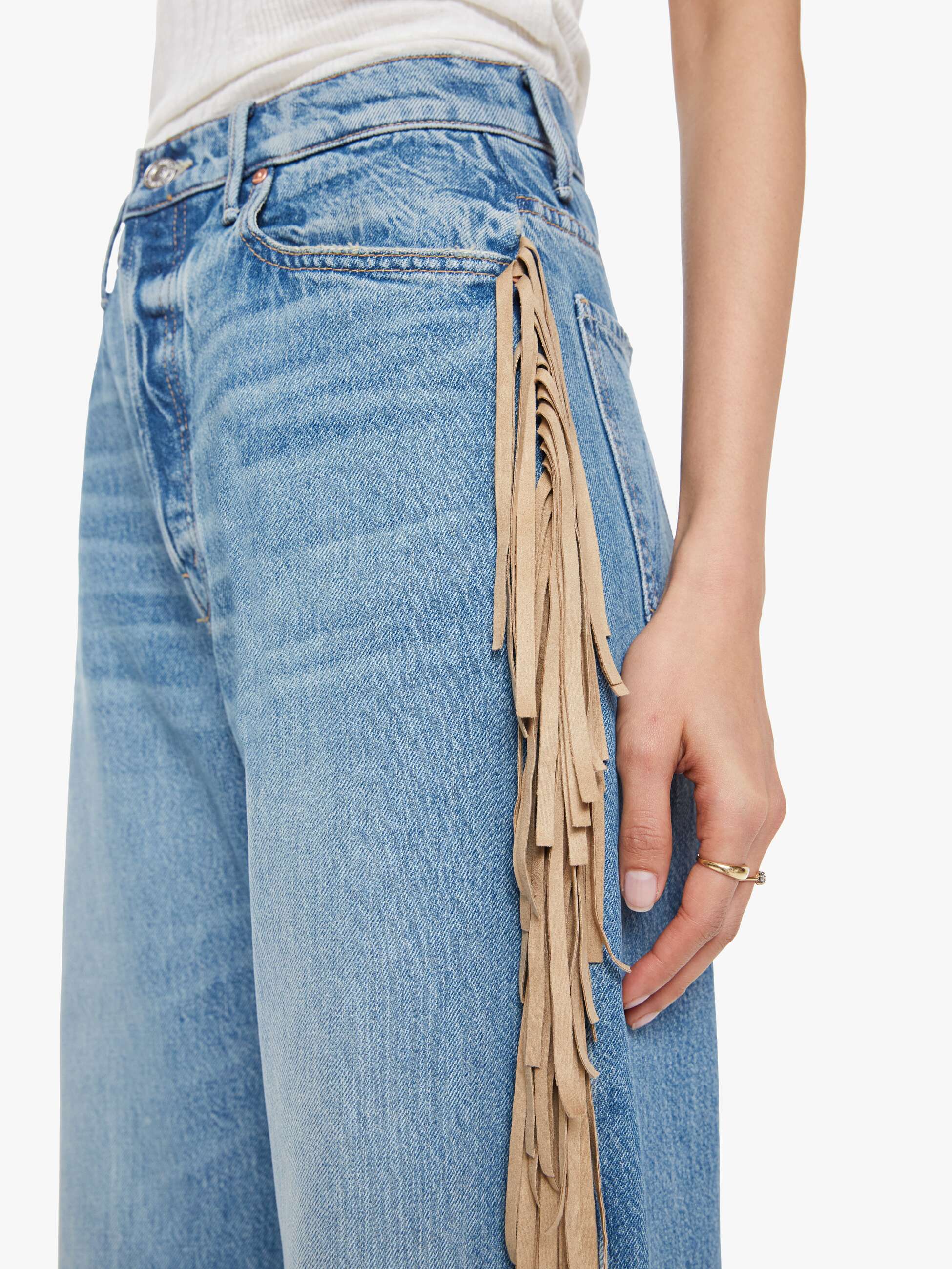 Blue jeans with fringe detail on a white background