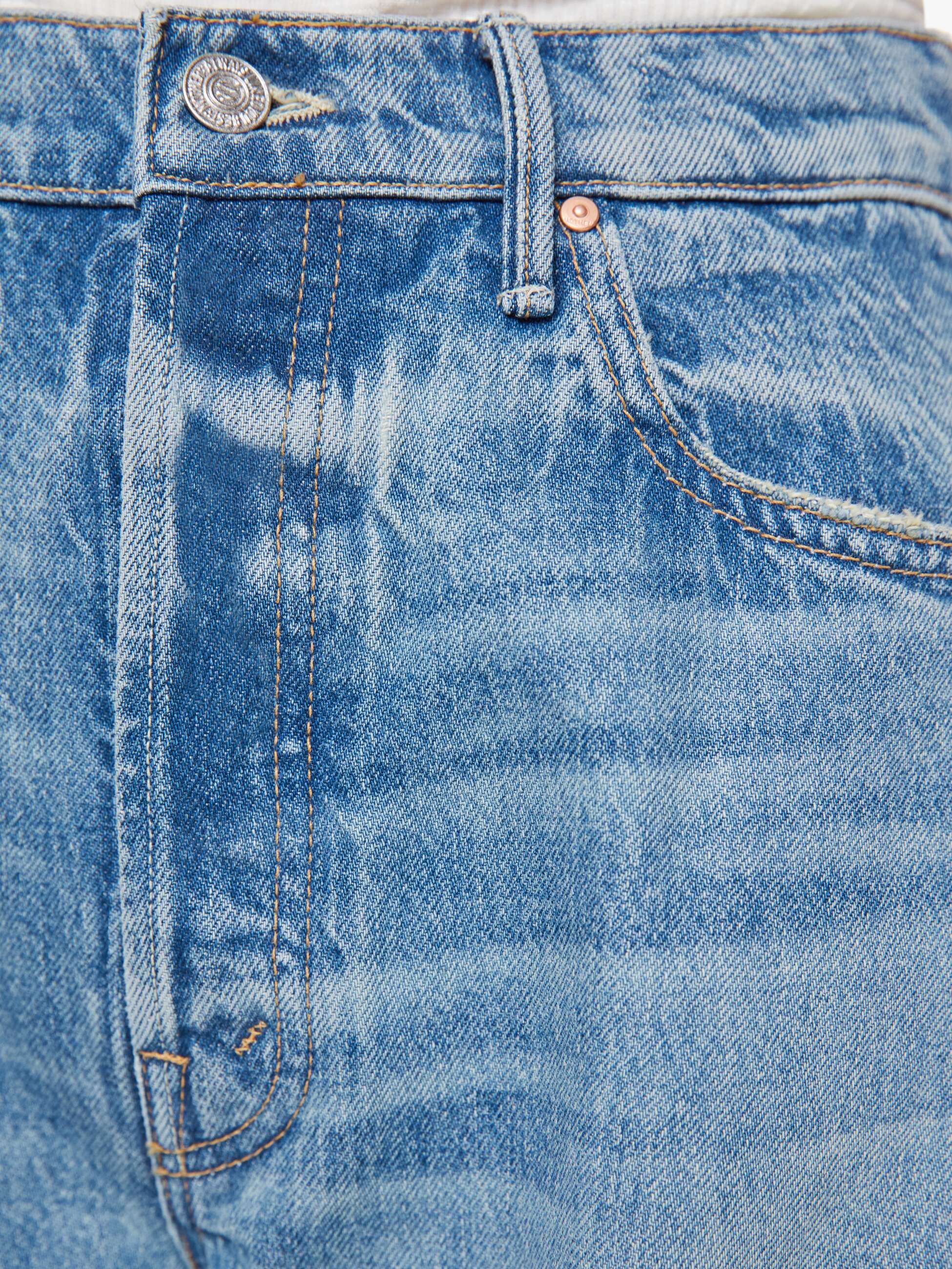 Close-up of blue denim fabric with stitching details