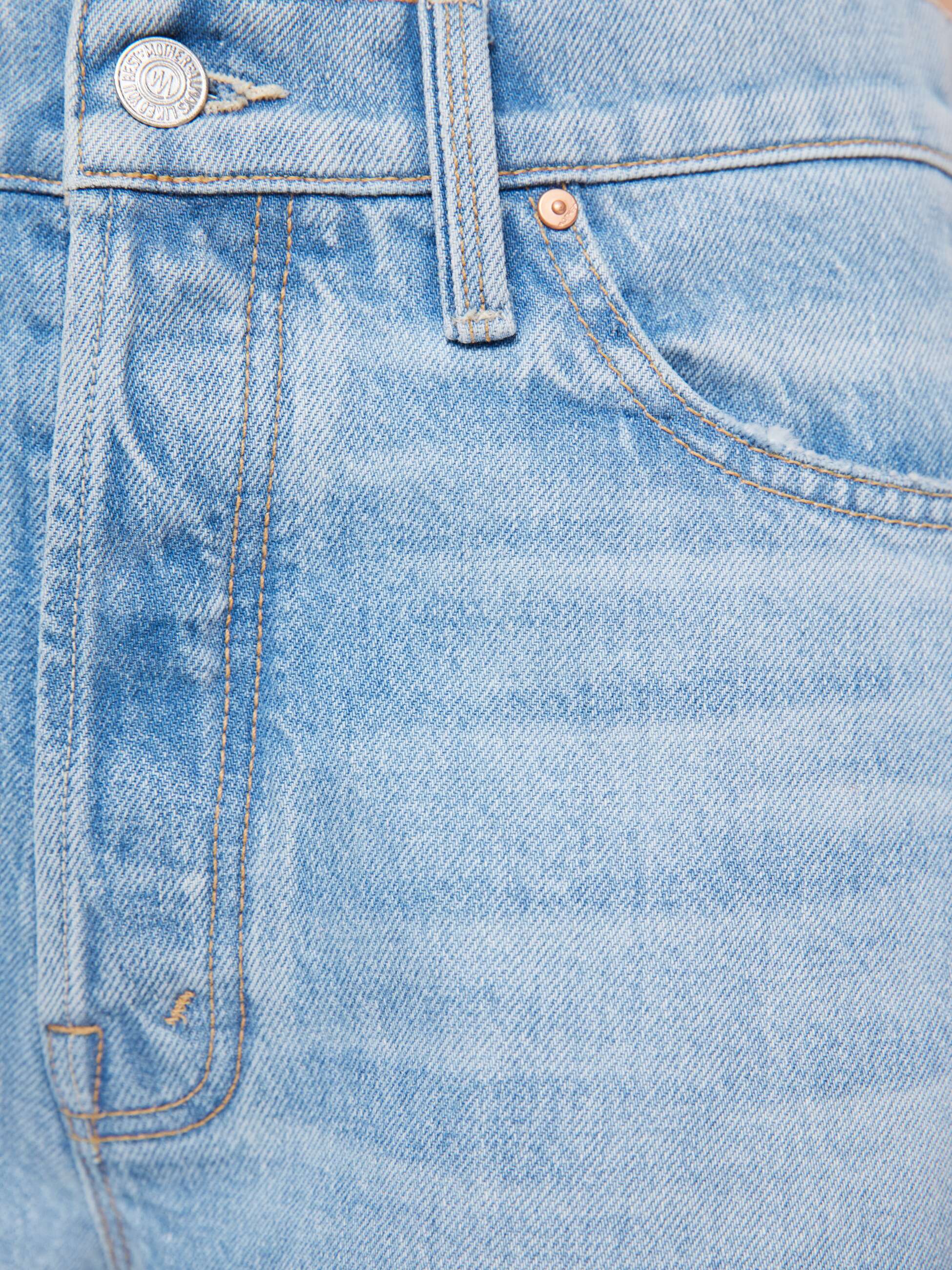 Close-up of light blue denim jeans with stitching details.