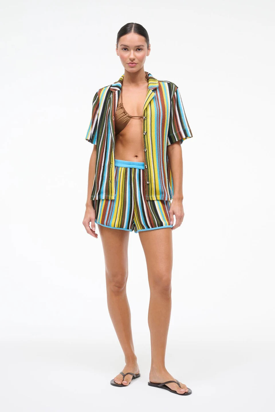 Woman wearing a colorful striped outfit on a white background