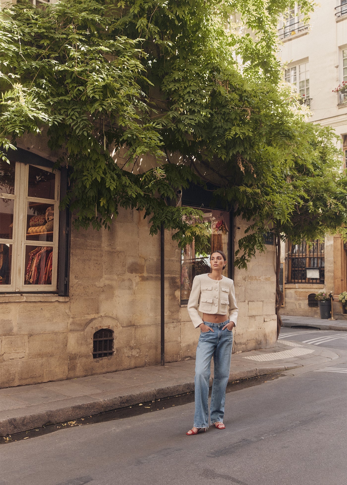 Woman wearing The Tommy Low Slung Straight standing on a street in an urban setting with trees and building