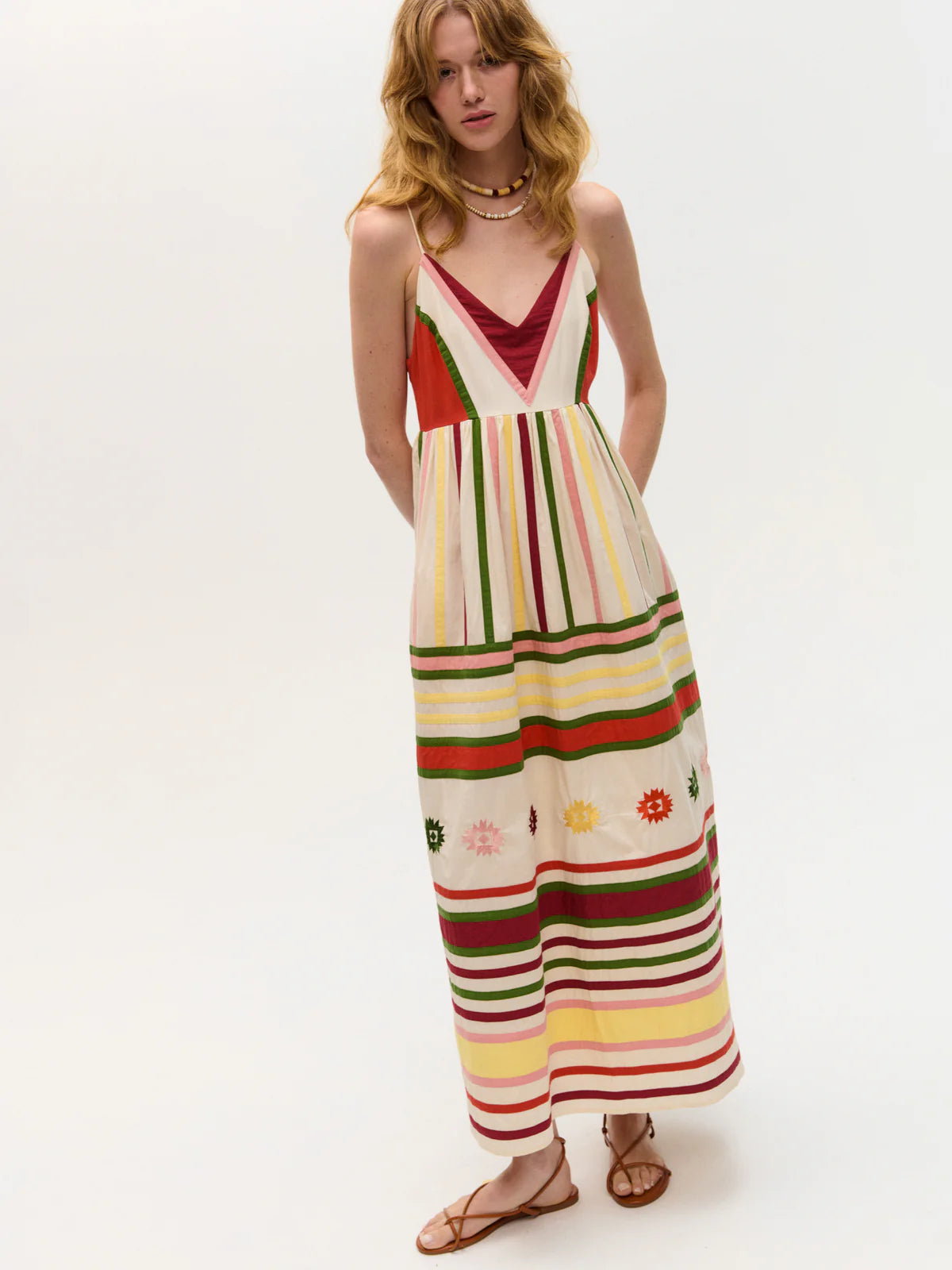 Woman wearing a colorful striped dress on a white background