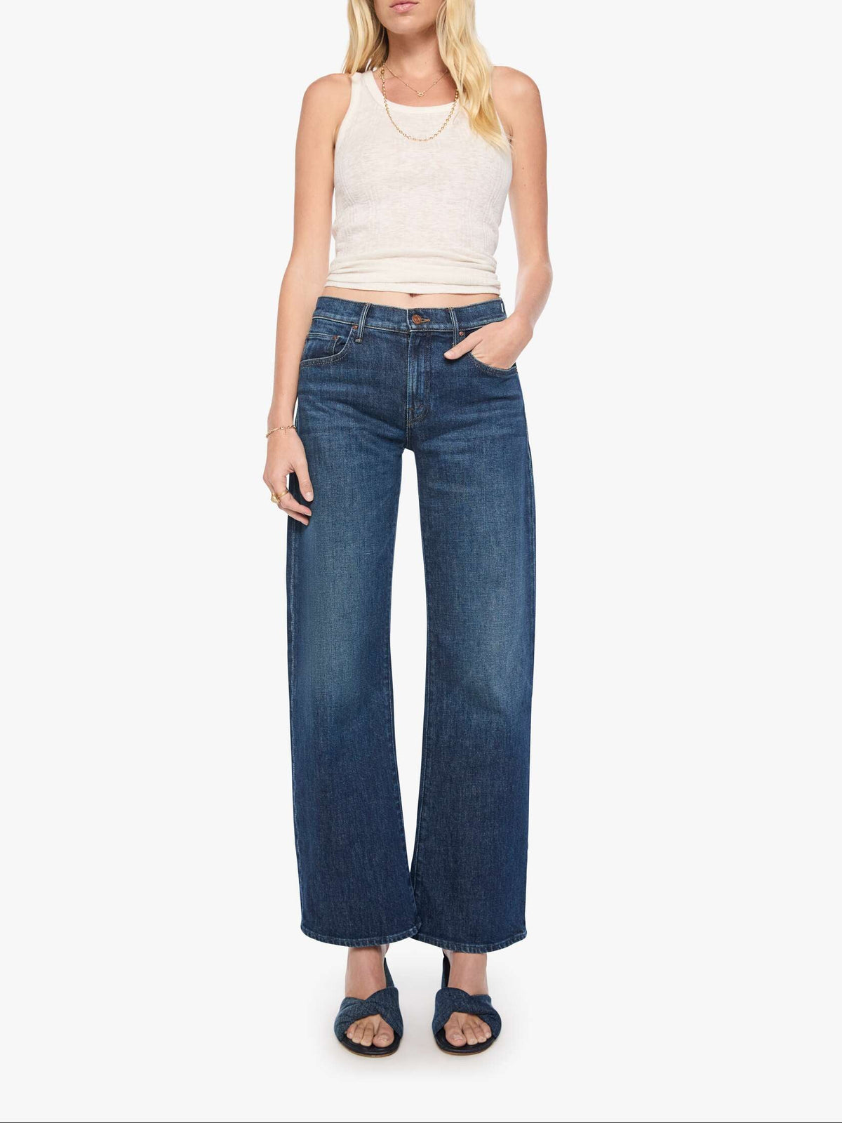 Woman wearing blue jeans and a white top on a white background