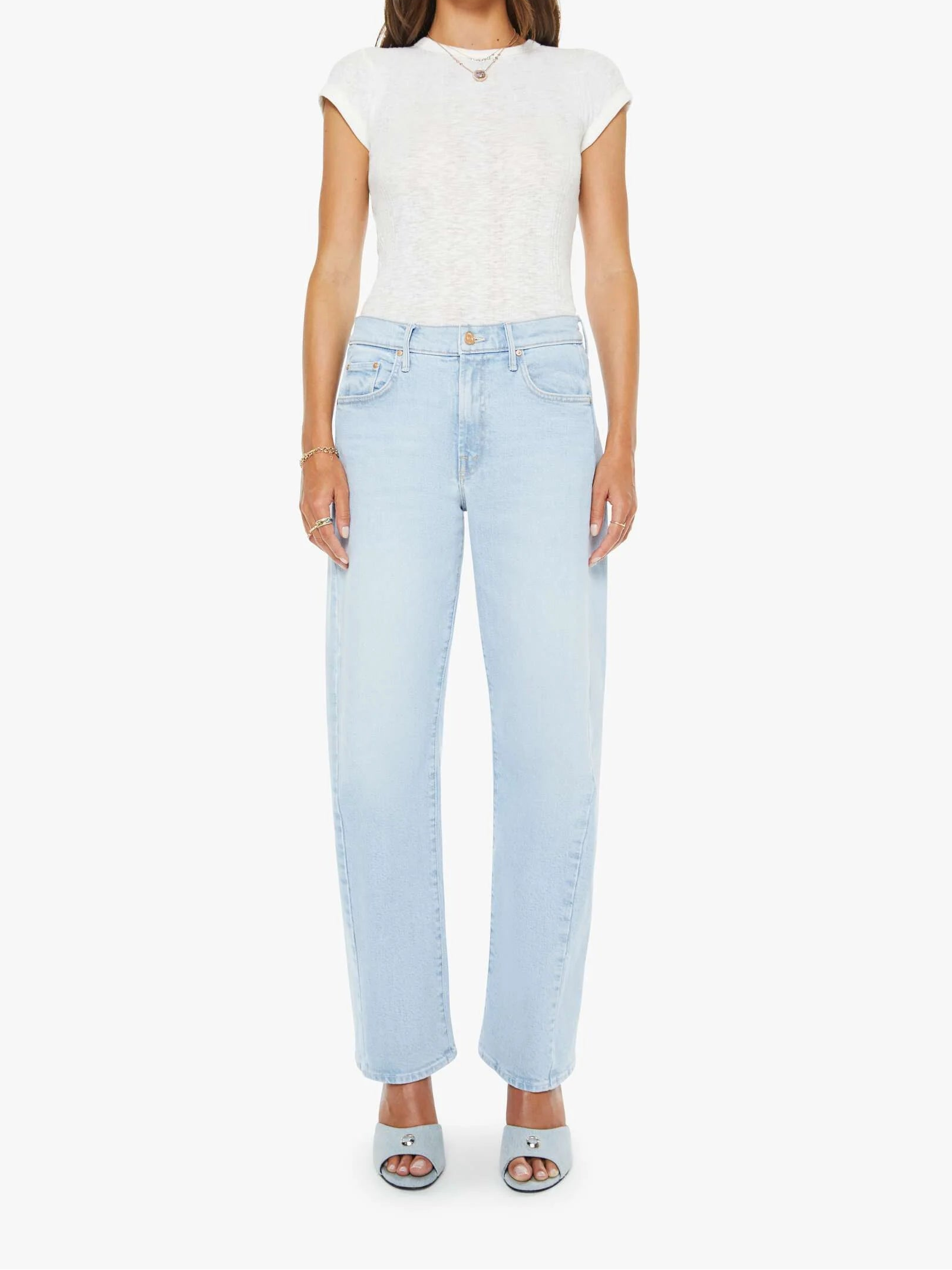 Woman wearing a white top and light blue jeans on a white background