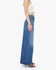 Woman wearing a white top and blue jeans on a white background