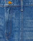 Close-up of blue denim fabric with a brand logo on a button.