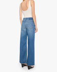 Woman wearing blue jeans and a white top on a white background