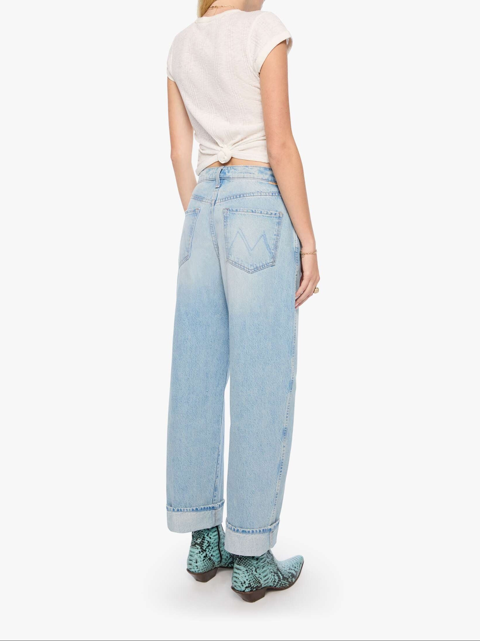Person wearing a white t-shirt and light blue jeans on a white background