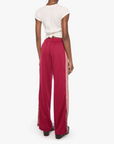 A model shown from the back wearing bright magenta wide-leg pants with white side stripes, paired with a white short-sleeve top, against a plain white background.