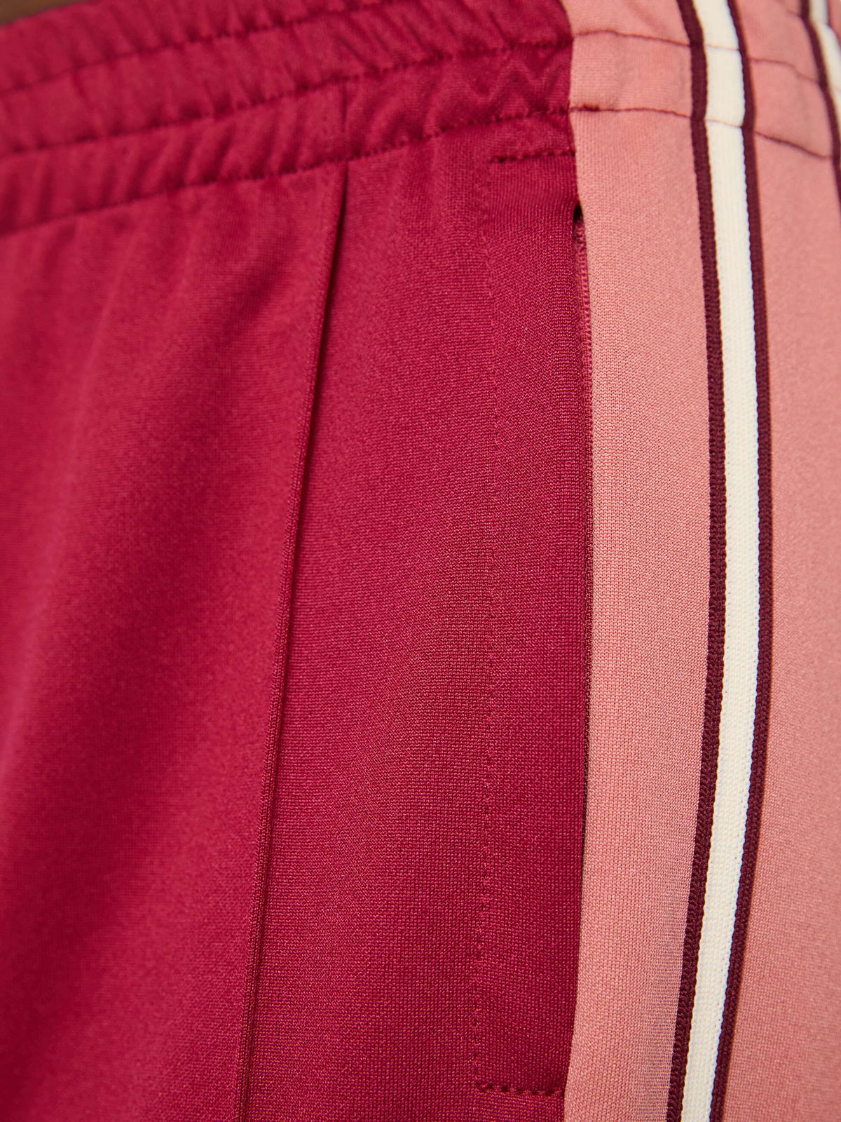 close up on track pants with stripes on the side