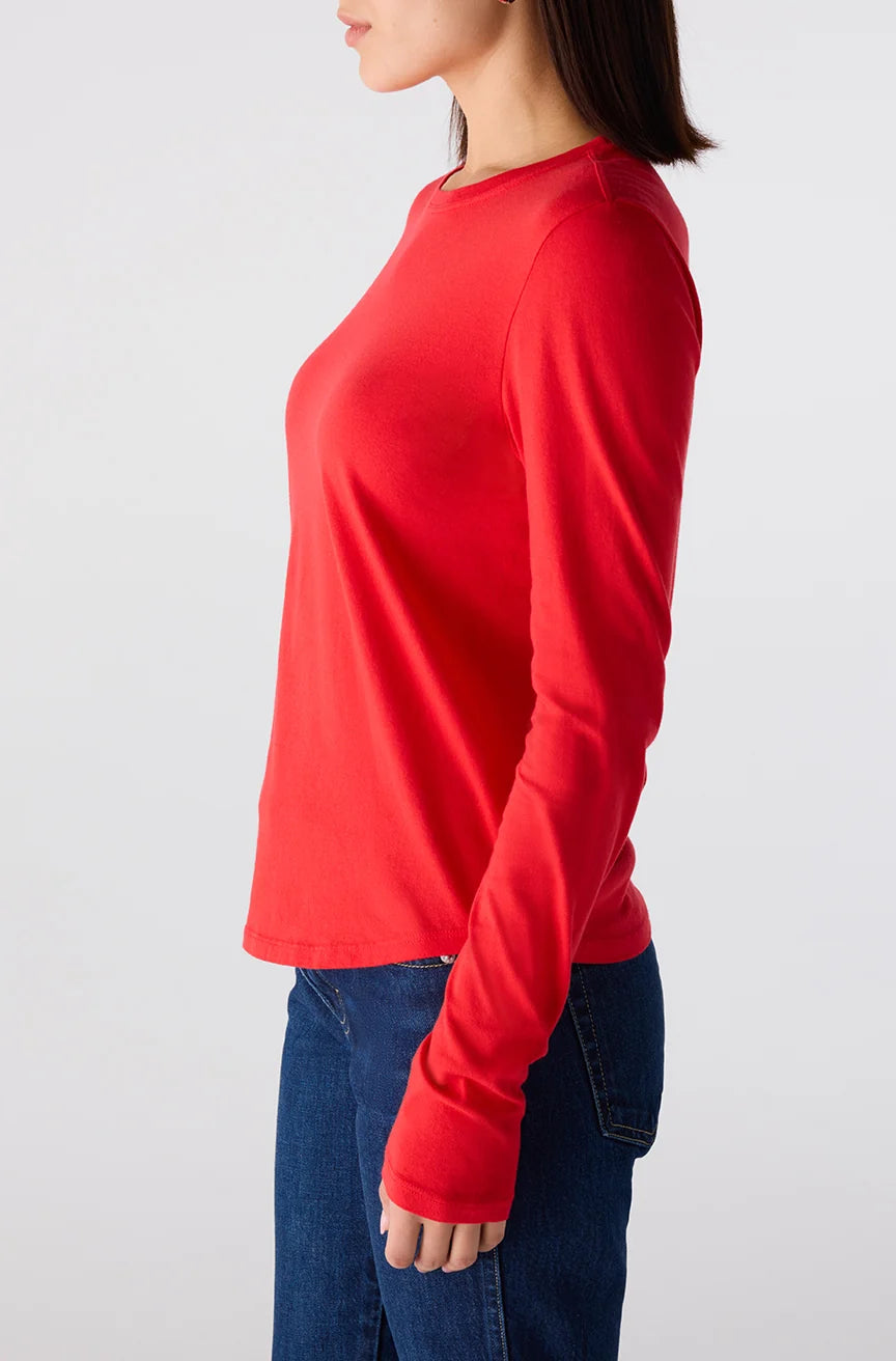 Person wearing a red long-sleeve shirt and blue jeans on a white background