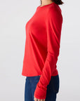 Person wearing a red long-sleeve shirt and blue jeans on a white background