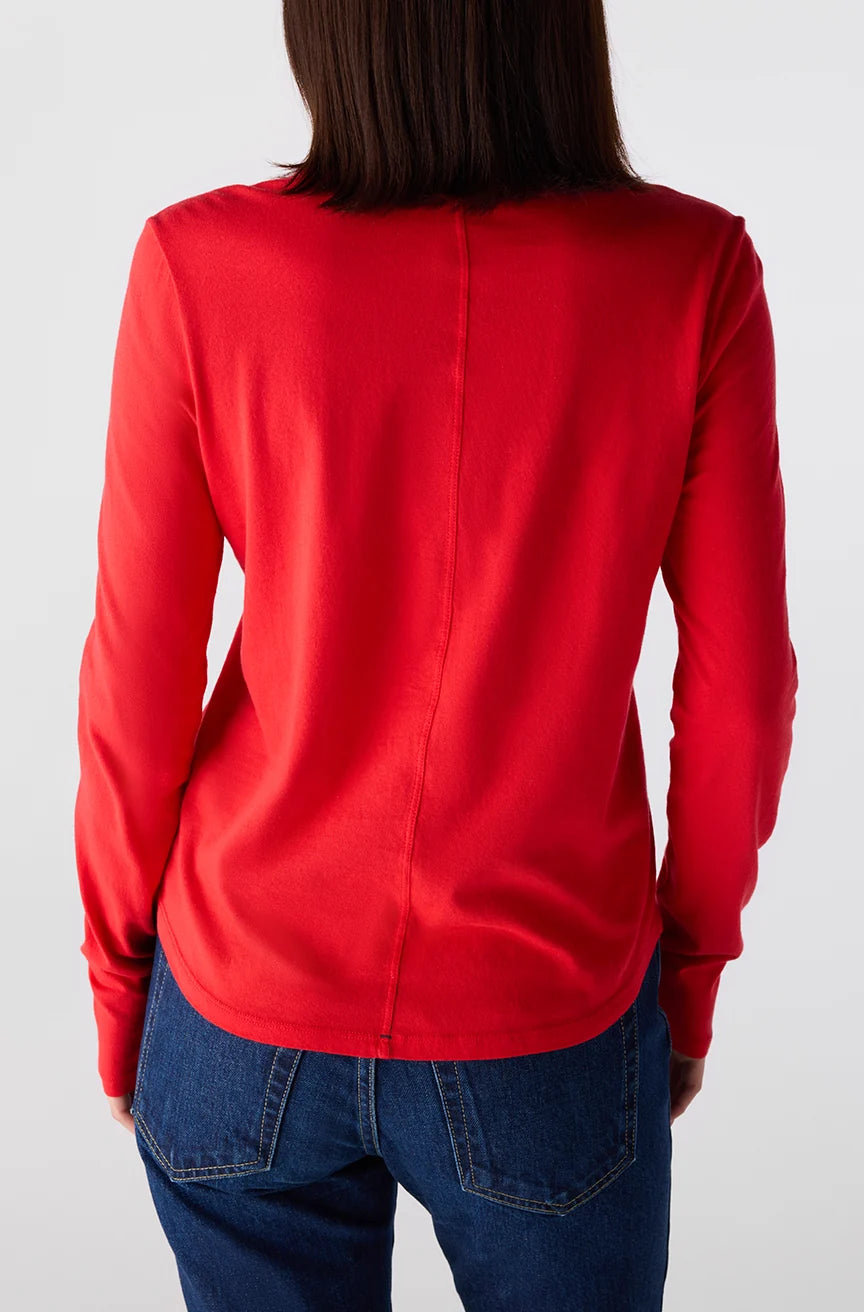 Person wearing a red long-sleeve shirt and blue jeans on a white background