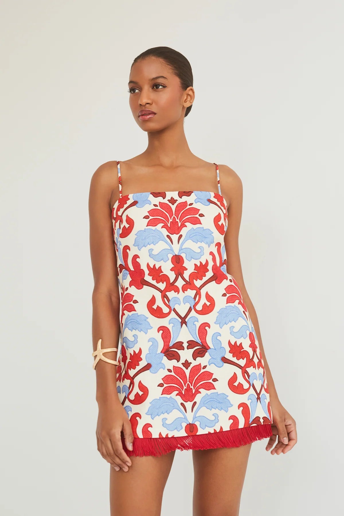 Woman wearing a floral patterned dress on a plain background