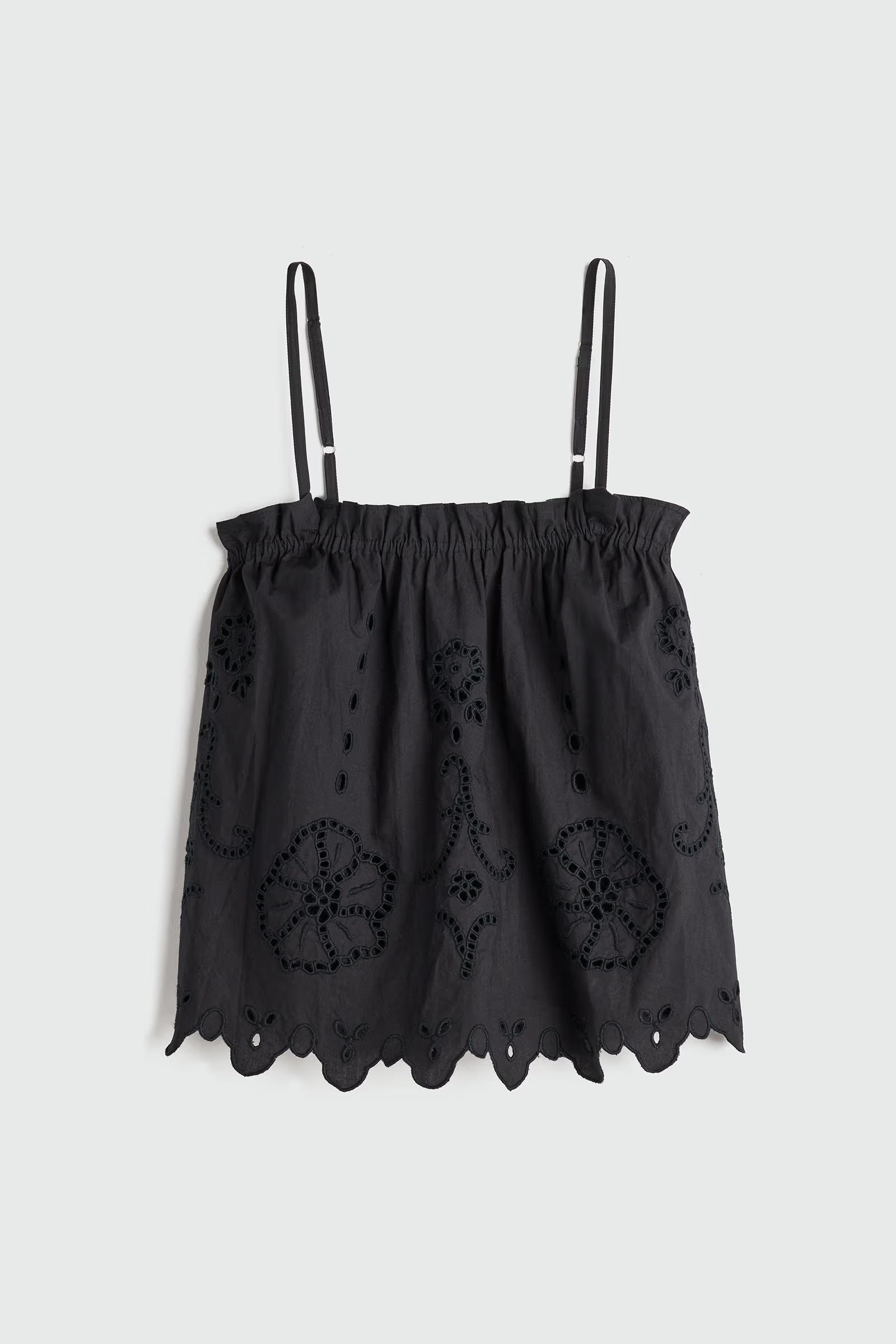 Black lace top with thin straps on a light gray background