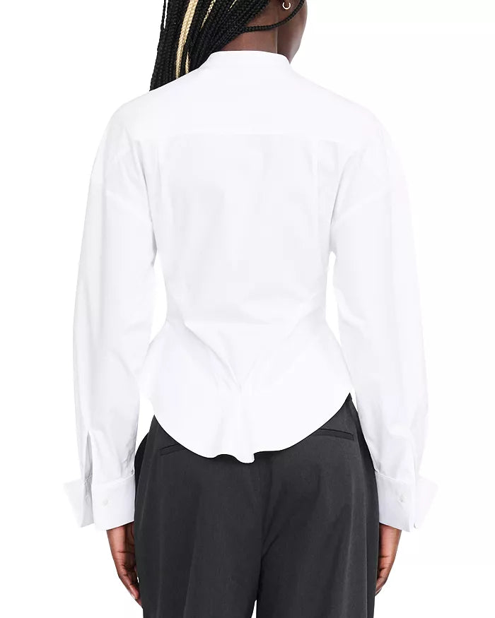 Back view of a person wearing a white long-sleeve button-up shirt tucked into dark charcoal pants, against a plain white background.
