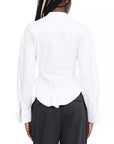 Back view of a person wearing a white long-sleeve button-up shirt tucked into dark charcoal pants, against a plain white background.