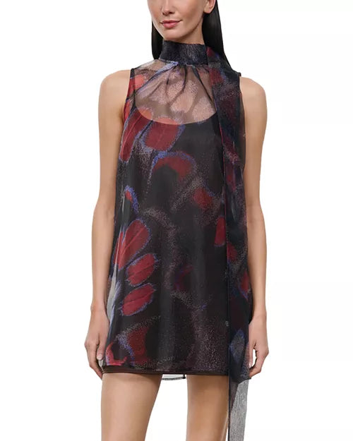 A sleeveless high-neck mini dress with a sheer mesh overlay and an abstract brushstroke pattern in red, purple, and black, shown on a model against a white background.