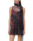 A sleeveless high-neck mini dress with a sheer mesh overlay and an abstract brushstroke pattern in red, purple, and black, shown on a model against a white background.