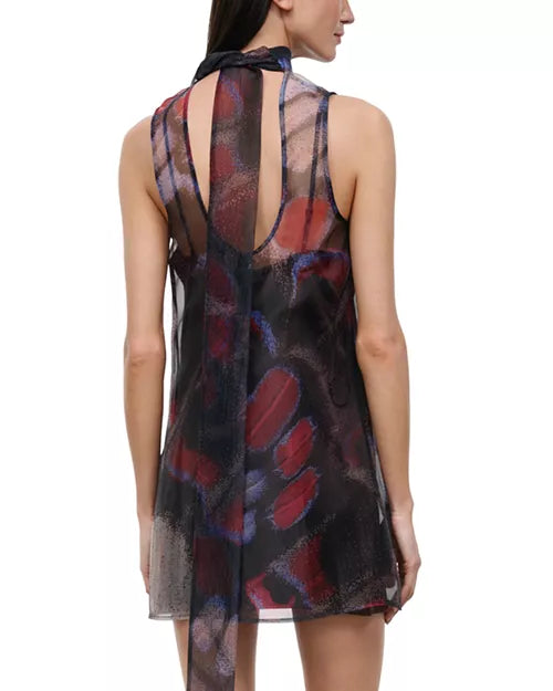 A sleeveless sheer mesh dress with an abstract brushstroke pattern in red, purple, and blue over a black base, shown from the back on a model against a white background.