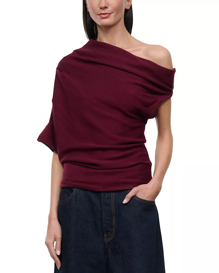 model wearing off shoulder pinot sweater with jeans on a white background