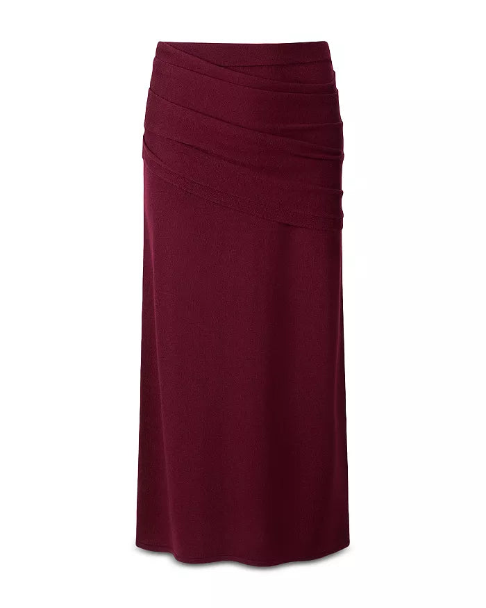 A draped midi skirt in deep burgundy, featuring a gathered waistband and flowing, asymmetrical folds, shown against a plain white background.