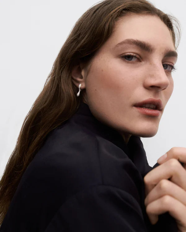 Close-up of a person wearing a black jacket against a plain background