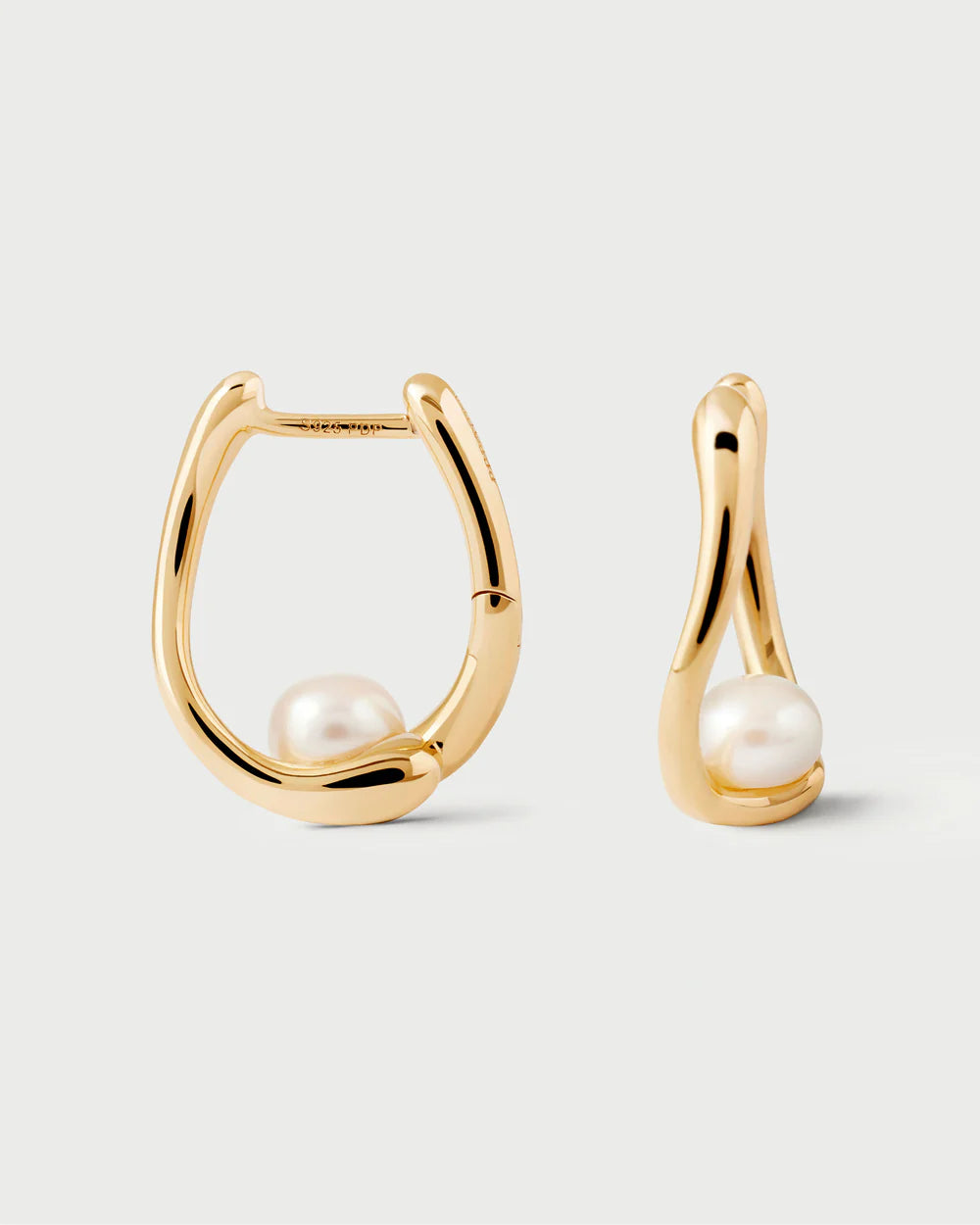 Gold hoop earrings with pearls on a light gray background