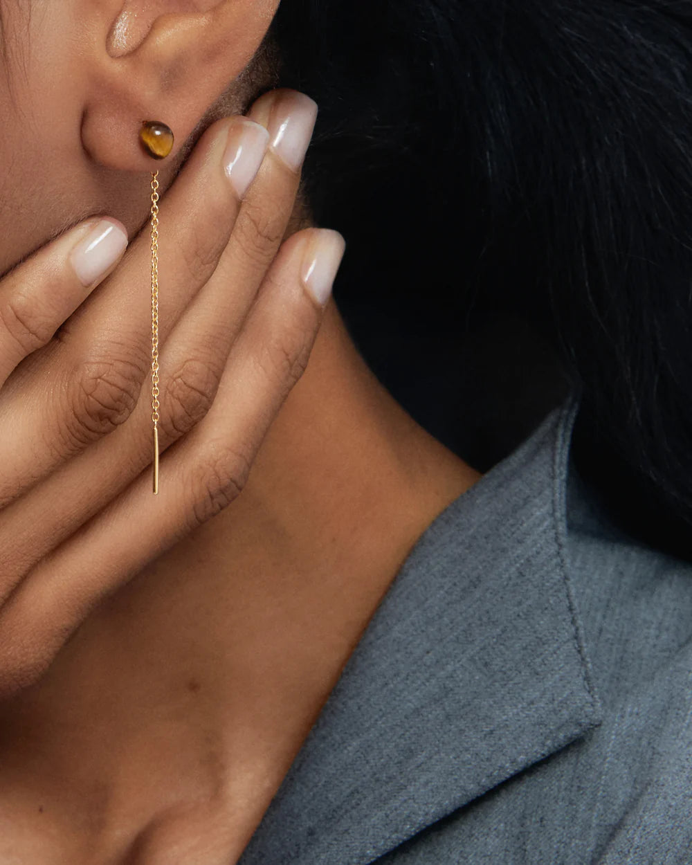 Close-up of a person wearing Tiger Eye Lyra Earrings