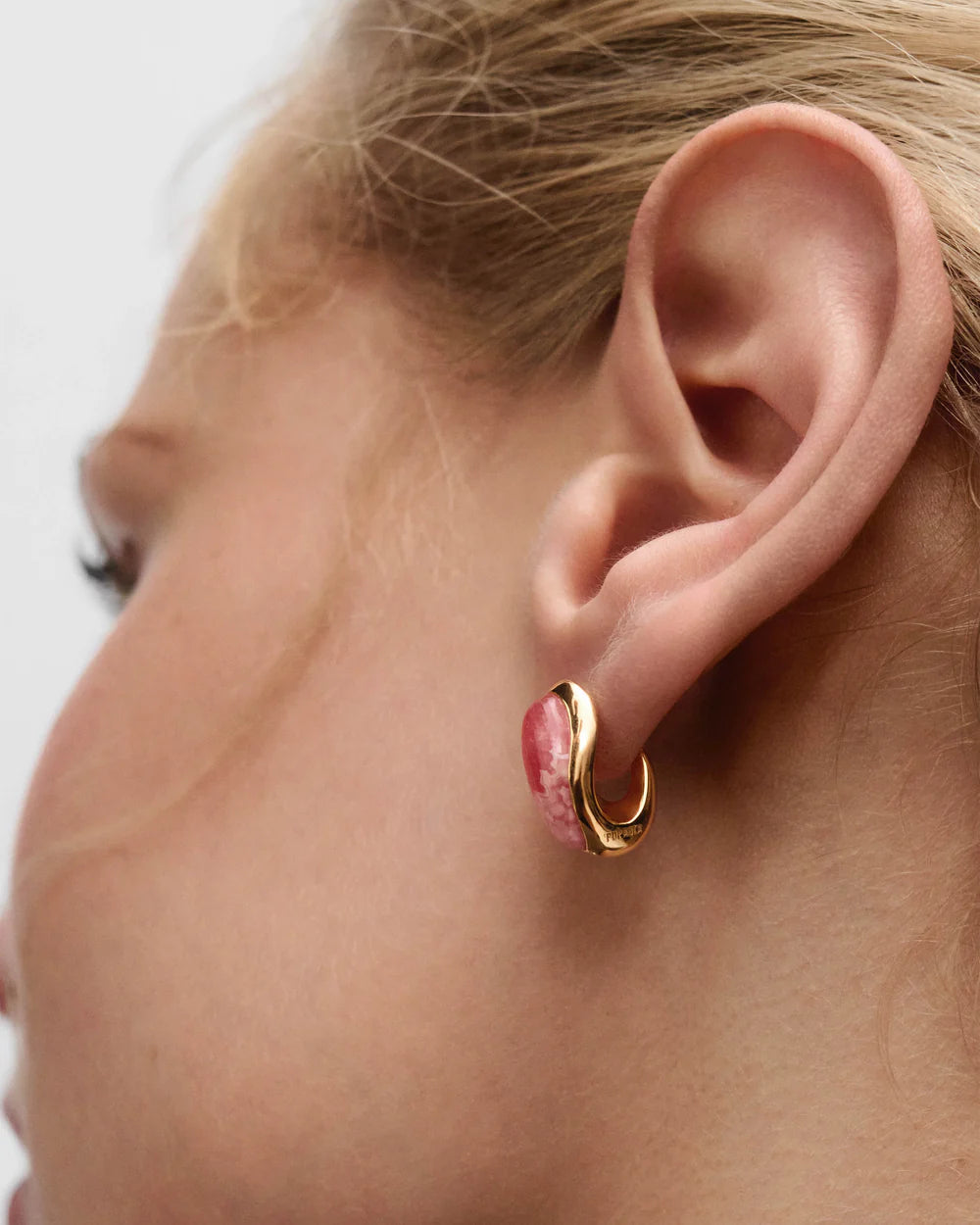 Close-up of an ear wearing Rhodochrosite Luna Earrings