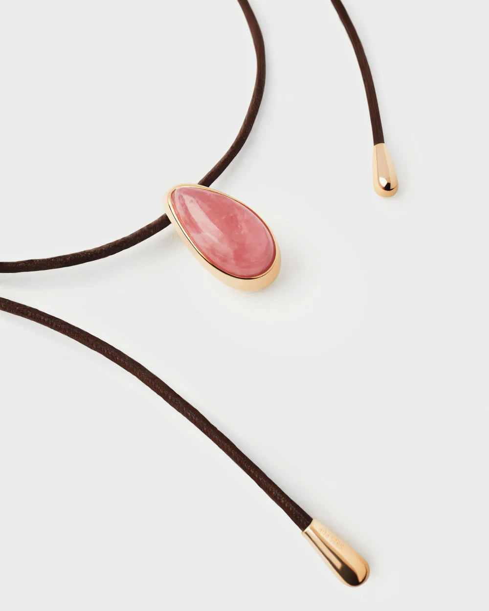 Necklace with a pink stone and gold details on a white background