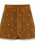 dottie mini skirt in saddle with gold studs on a white background