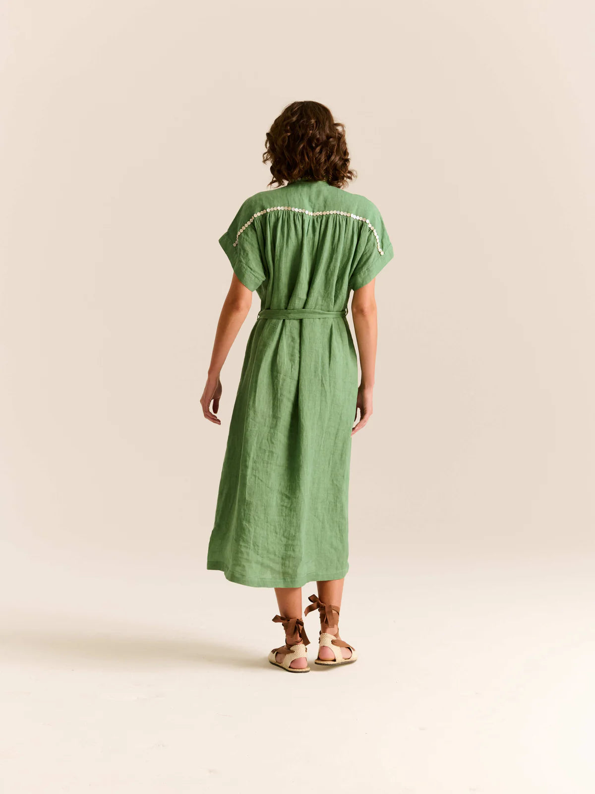 Woman wearing a green dress on a beige background
