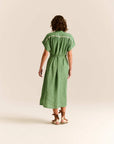 Woman wearing a green dress on a beige background