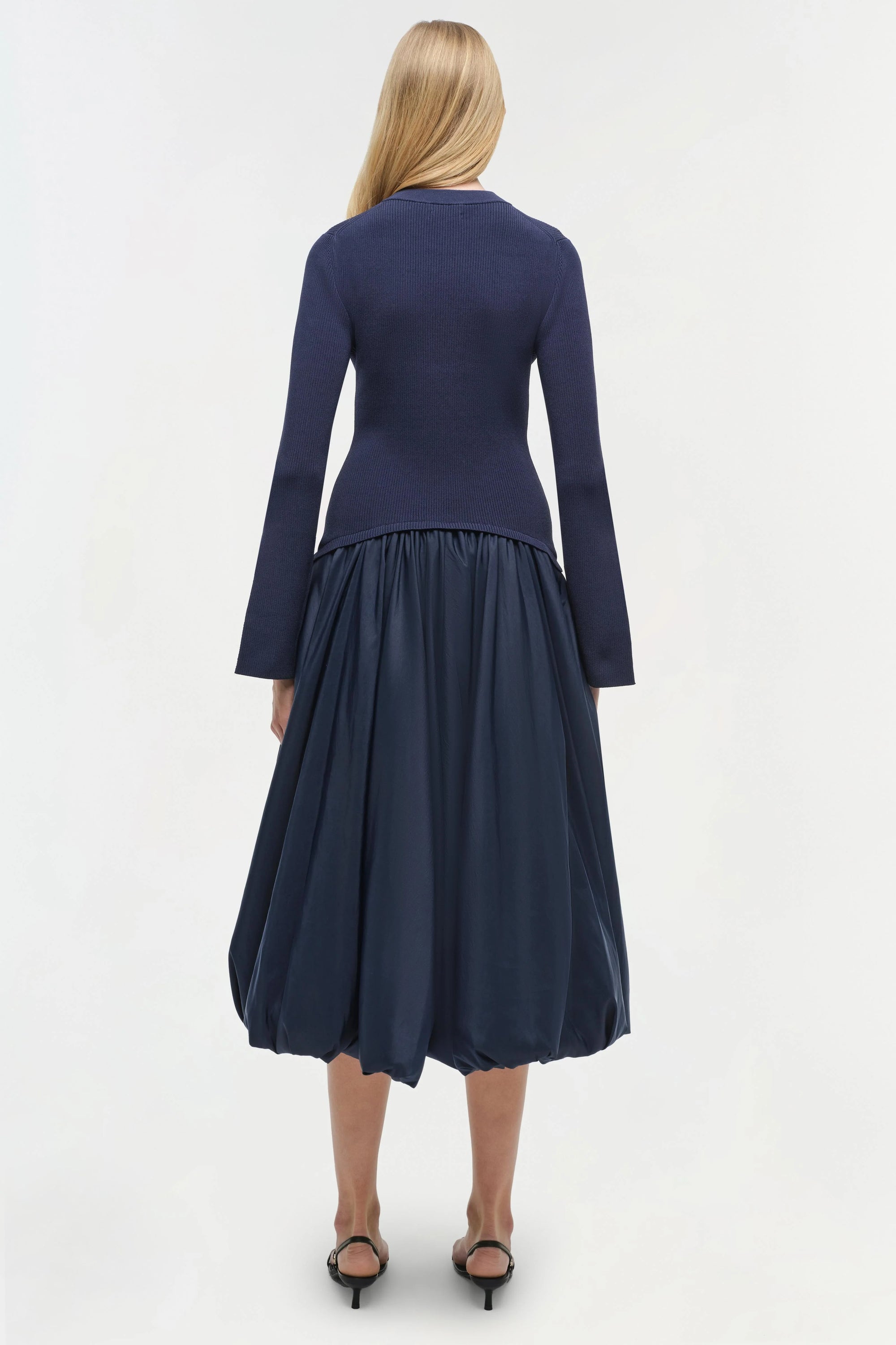 Navy blue dress with long sleeves and a full skirt on a white background back 