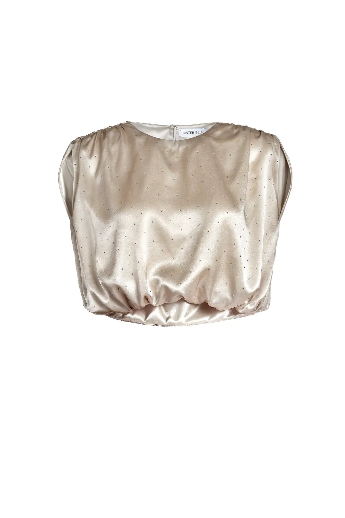 A champagne gold satin crop top with a subtle dotted pattern, featuring a gathered puff sleeve and a ruffled hem, shown against a plain white background.