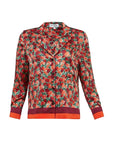 A long-sleeve button-front shirt jacket with a dense red, orange, and green floral print, featuring solid dark red cuffs and a matching dark red hem, shown on a plain white background.
