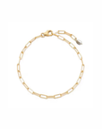 A delicate gold chain bracelet with elongated paperclip links, a lobster clasp, and a small teardrop pearl accent, displayed on a clean white background.