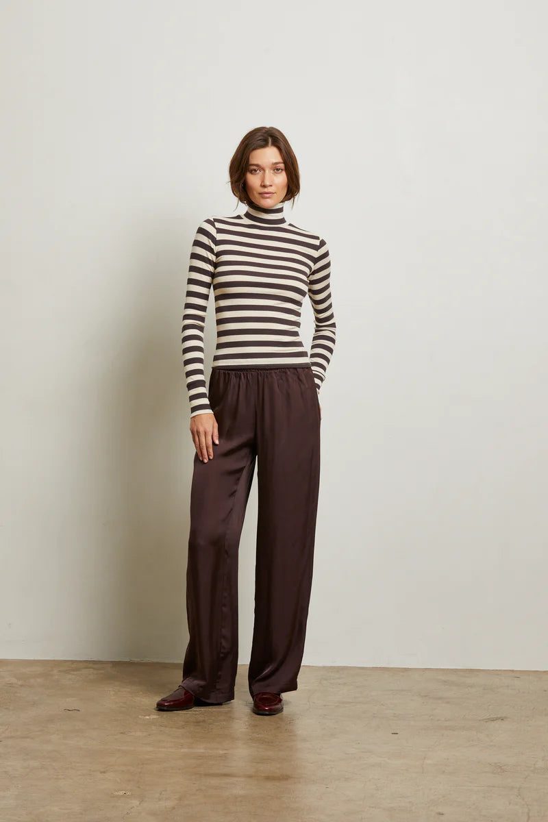 Person wearing a striped sweater and brown pants against a plain background front view