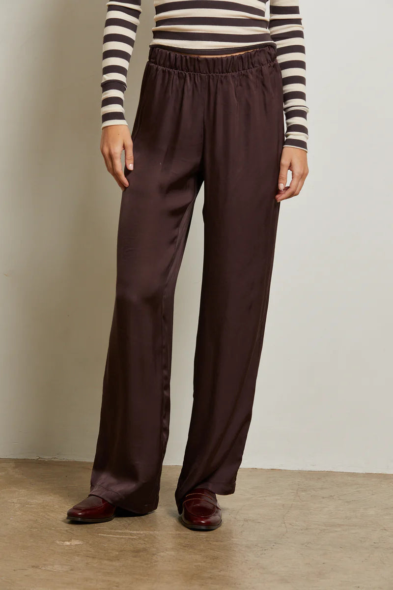 Person wearing brown wide-leg pants and a striped shirt against a plain background front view