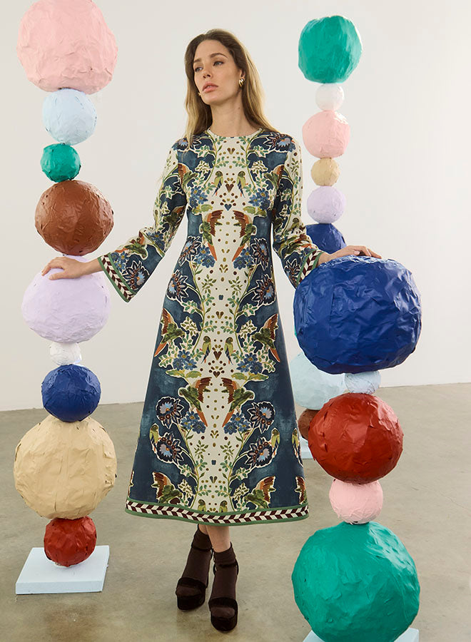 model wearing a print dress with art balls around her and a white background