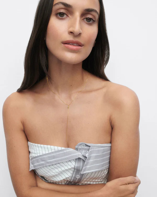 Woman wearing a strapless top and Tessa Necklace with a white background