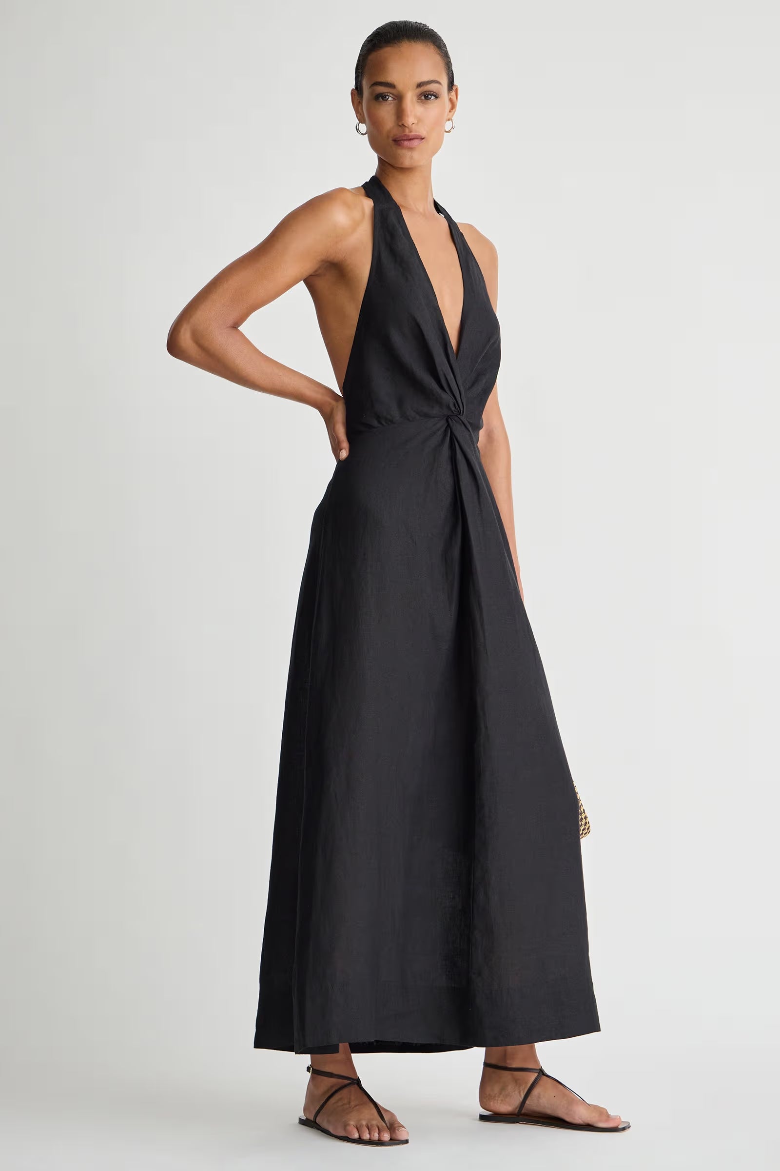 Woman wearing a black halter neck dress on a white background