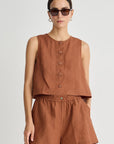 Woman wearing a matching linen tank and shorts set with center front buttons