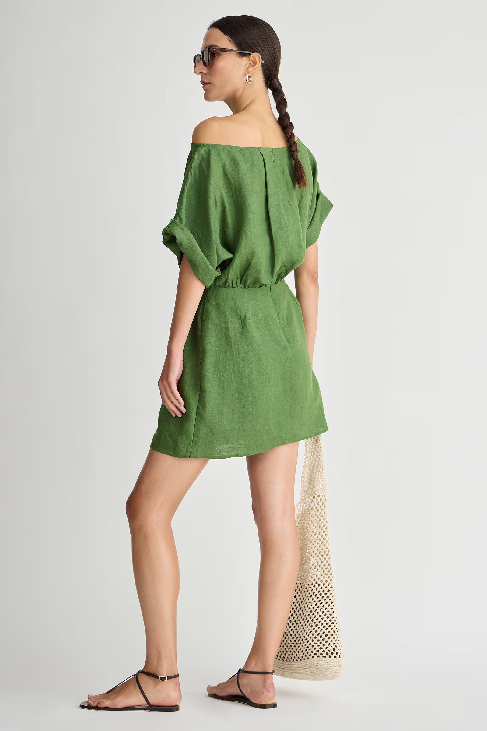 Woman wearing a green off-shoulder dress on a white background