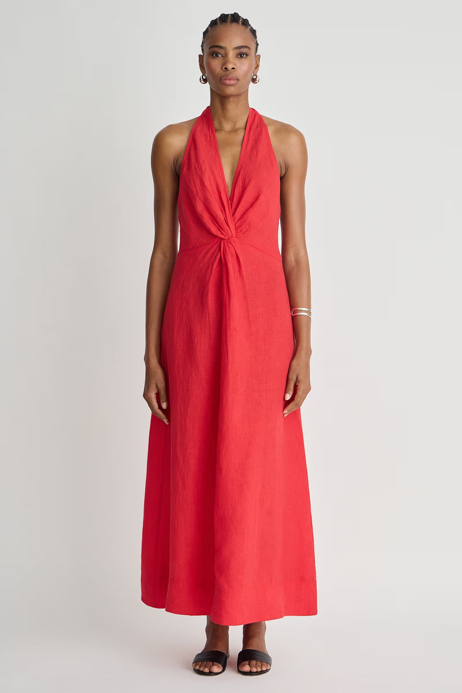 Woman wearing a red halter neck dress on a white background