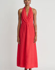 Woman wearing a red halter neck dress on a white background